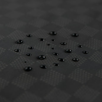 Close-up of water droplets on the Bumkins Wet/Dry Clutch: Rich Black waterproof fabric.