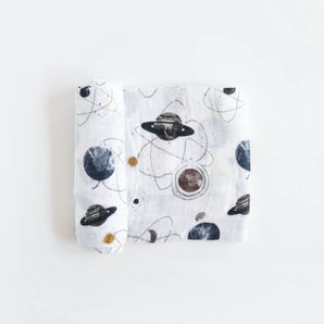 Lightweight cotton swaddle by Little Unicorn with space-themed prints of planets and stars. Folded neatly.