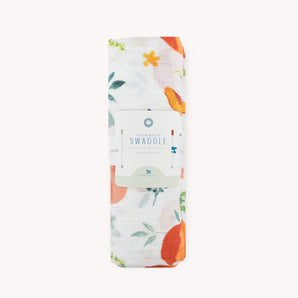 The Little Unicorn Cotton Swaddle, Georgia Peach, features hand-painted prints and comes wrapped in a branded orange floral label.