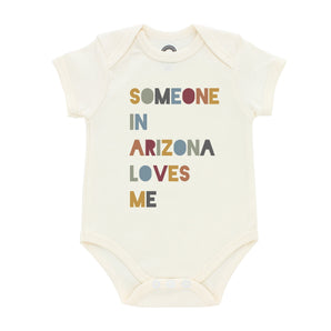 Emerson and Friends Luxury Bodysuit, featuring Someone in Arizona loves me, is machine washable and crafted from premium beige cotton.