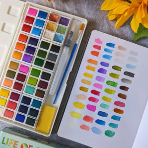 Life of Colour Portable Watercolor Set includes brushes and a notebook with swatches. Bright sunflowers complete the scene.