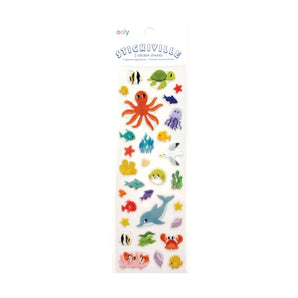 The Stickers, Sand and Sea sheet by OOLY features vibrant vinyl stickers of ocean animals like an octopus, turtle, fish, crabs, jellyfish, and starfish arranged in a fun pattern. The packaging displays Stickiville.