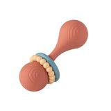 The non-toxic Rattle, Simply Silicone Coral by Mary Meyer features a rattle-shaped design with two round, brown sections connected by a narrow handle, enhanced by concentric circles and blue and cream-colored rings, making it perfect for teething infants.