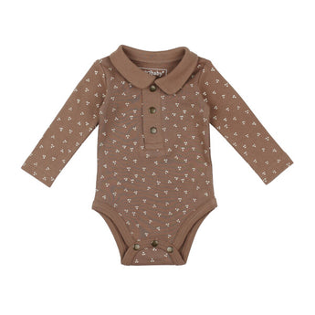 Lovedbabys Organic Polo Bodysuit in Latte Dots is a brown onesie with a collar, long sleeves, button-up front, and snap closures. Made from organic cotton with eco-friendly dyes, it features a small white floral pattern.