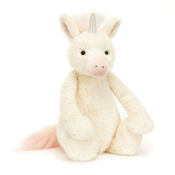 Jellycats Bashful Unicorn Big sits upright, featuring a holographic horn, soft vanilla fur, and a pink mane and tail.