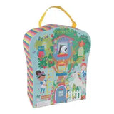 The Rainbow Fairy Playbox by Floss and Rock is a colorful, childrens book-shaped box featuring kids and wooden characters around a treehouse, adorned with flowers, a picket fence, multicolored striped edges, and equipped with a yellow handle.