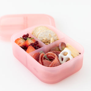 The Bumkins Silicone Bento Box Pink Jelly holds strawberries, pomegranate, and yogurt pretzels in LFGB-grade silicone sections.