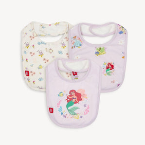 The Magnetic Me 3-Pack Bib Disney Princess set features three eco-friendly TENCEL™ bibs adorned with soft pastel Disney designs: one with fairies and flowers, another with a mermaid and fish, and the third echoing the mermaid theme. Each ensures comfort with a gentle magnetic closure.