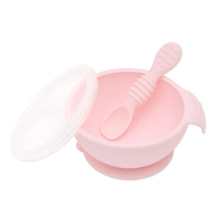 Bumkins Silicone First Feeding Set in Pink includes a bowl with lid, matching spoon, and suction base for easy self-feeding.