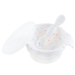 Bumkins Silicone First Feeding Set: Vanilla Sprinkle includes a white speckled bowl, lid, spoon, and secure suction base.