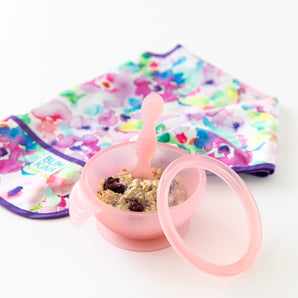 Bumkins Silicone First Feeding Set: Pink Jelly—a pink LFGB silicone bowl, porridge, berries, and a floral bib.