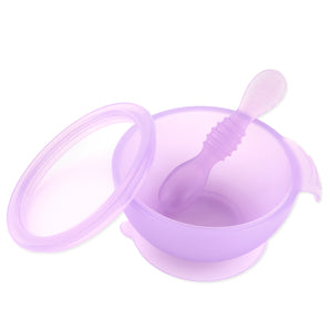 The Bumkins Silicone First Feeding Set in Purple Jelly is a translucent purple silicone baby feeding bowl with a lid and matching spoon. Made from LFGB-grade silicone, it features a suction base for stability.