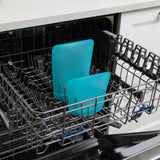 Bumkins Blue Silicone Flat Reusable Bags sit in an open dishwashers bottom rack of an eco-friendly kitchen.