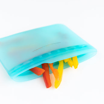 Blue Bumkins Silicone Flat Reusable Bag packed with red, yellow, and orange bell pepper slices features a child-friendly zip seal.