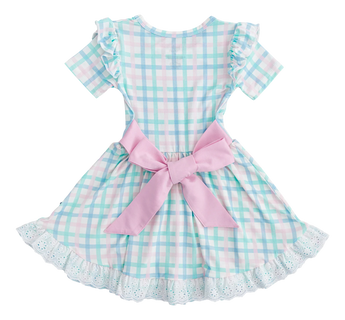 The Pastel Gingham Birdie Dress by Birdie Bean is crafted from plush bamboo viscose and features a pastel plaid in light blue, pink, and white checks. It boasts short sleeves, ruffled shoulders, a pink back bow, and a lacy white hem for comfort and charm.