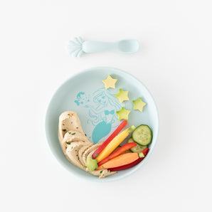 The Bumkins Disney Princess Ariel Silicone Plate + Spoon Set holds hummus, carrots, and cucumber stars.