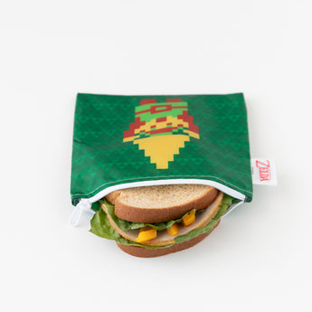 A sandwich peeks from a reusable, machine washable pouch with a character and shield design by Bumkins, Zelda™ Snack Bag 3-Pack.