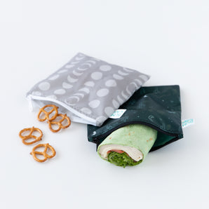 Bumkins Reusable Snack Bag, Large 2 Pack: Desert Night lays on a white background, holding a wrap and pretzels.