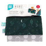 Two Bumkins Desert Night reusable snack bags, made from waterproof fabric, are shown against a packaging card. The top bag has a dark green background with cacti, stars, and moons, while the bottom features gray with large white polka dots. Ideal storage for travel in a 2-pack for ages 3+.