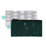 The Reusable Snack Bag, Small 2 Pack: Desert Night by Bumkins includes two waterproof zippered bags for storage and travel. One bag has a dark green cactus and moon design, while the other features gray with white half-circles; both have Bumkins tags.