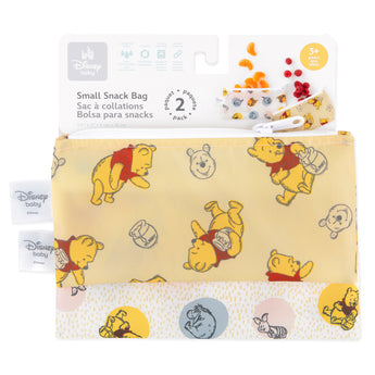 Two Bumkins reusable snack bags, small 2 pack featuring Pooh Bear and Friends prints, are shown with whimsical designs. Made from waterproof fabric, the packaging displays the Disney Baby logo and indicates suitability for ages 3 and up.