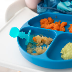 Blue divided baby plate with carrots & puree on a highchair tray, paired with Bumkins Blue Jelly Silicone Chewtensils®.