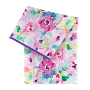 The Splat Mat: Watercolor by Bumkins showcases a stain-resistant floral design with pink, purple, green, and blue on white.