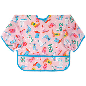 Bumkins Sleeved Bib: Boots features a vibrant cowboy boot print on pink waterproof fabric with blue trim and pocket.