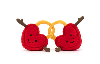 The Jellycat Amuseables Val & Tina Love Locks are plush red hearts with soft fur, linked by golden yellow locks. Each heart has brown arms in a welcoming gesture, set against a white background.