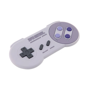 Bumkins Silicone Teether: Nintendo SNES™ Controller has a gray design, purple buttons, and directional pad for nostalgic gum relief.