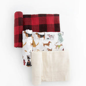 The Cotton Swaddle Set, Woof by Little Unicorn includes a breathable red checkered, dog prints, & solid cream muslin blankets on white.