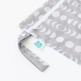 Close-up of Bumkins Wet Bag: Lunar Phase on a white background, showcasing the side strap and logo label.