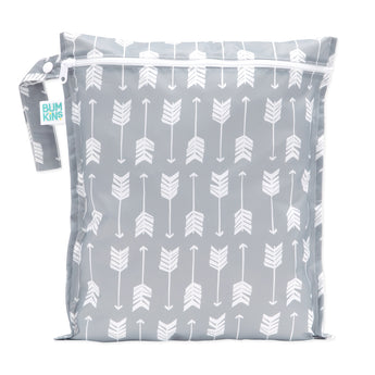 Bumkins Wet Bag: Arrow is a grey waterproof bag, made from durable fabric with a white arrow pattern and a side brand tag. It features a zipper closure and small handle, making it part of Bumkins reliable reusable wet bags collection.