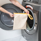 Someone puts a Bumkins Wet Bag: Sunshine in a gray front-load washing machine.