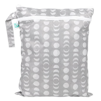 The Bumkins Wet/Dry Bag: Lunar Phase, featuring a crescent moon pattern in gray, has a top zipper and small side handle. Made from waterproof fabric, it serves as an organizer bag with a green tag displaying text.