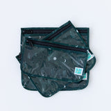 The Bumkins Clear Travel Bag 3 Pack: Starry Cactus features TSA-compliant, reusable bags with cactus and moon patterns, black zippers, varying sizes, stacked on top of each other, and a visible Bumkins label.