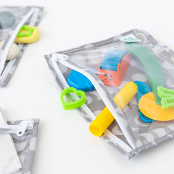 Bumkins Clear Travel Bag 3 Pack: Lunar Phase holds colorful cookie cutters and play dough on a white table.