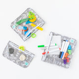 Bumkins Clear Travel Bag 3 Pack: Lunar Phase filled with colorful toys, markers, and modeling clay on a white background.