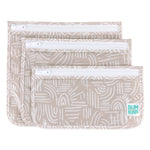 Three beige Wander bags by Bumkins with white patterns and clear tops, each in a different size, stacked diagonally.