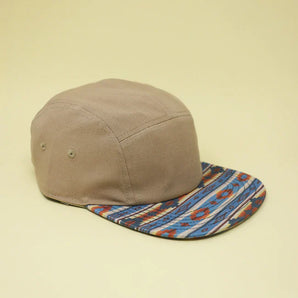 Storied Hats Adult Hat in Khaki Southwest features a colorful, patterned flat brim on a light yellow background.