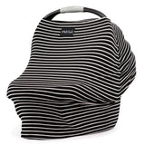 The car seat features the Milk Snob Cover Modern Stripe, elegantly draped in black and white stripes with a discreet label. This multifunctional cover fully conceals the seat, adding style and versatility.