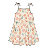 The Emerson and Friends Sundress, Sandy Seashells, boasts thin shoulder straps tied in bows and a delightful pattern of starfish, shells, and coral in pastel peach, pink, and teal on a light backdrop. Made from buttery soft bamboo for superior comfort.