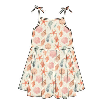 The Emerson and Friends Sundress, Sandy Seashells, boasts thin shoulder straps tied in bows and a delightful pattern of starfish, shells, and coral in pastel peach, pink, and teal on a light backdrop. Made from buttery soft bamboo for superior comfort.