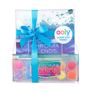 The OOLY Pearlescent Watercolor Gift Set includes 12 paints and Chroma Blends paper, wrapped with a blue ribbon and tag for projects.