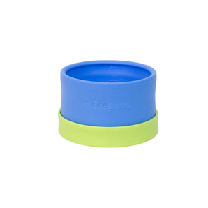 A blue morepeas Essential Snack Bowl with a green suction base and measuring lines inside.