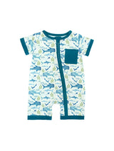 The Emerson and Friends Romper, Shark Friends, is a buttery soft bamboo shortie romper featuring a charming sea creature pattern with whales, seaweed, and sharks. It has teal trim on the light blue background plus a handy front pocket for added appeal.