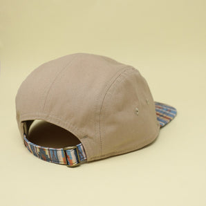 The Lil Hat from Storied Hats is a Khaki Southwest cap with a patterned brim and an adjustable strap, made of organic cotton.