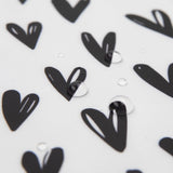 The Bumkins Wet Bag: Hearts features black heart patterns on white waterproof fabric with shimmering water droplets.