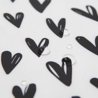 Close-up of Bumkins Reusable Snack Bag in Hearts design: waterproof fabric with black hearts and water droplets.