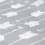 Close-up of water droplets on gray waterproof fabric with a white arrow pattern, highlighting the Bumkins SuperBib®: Arrow durability.